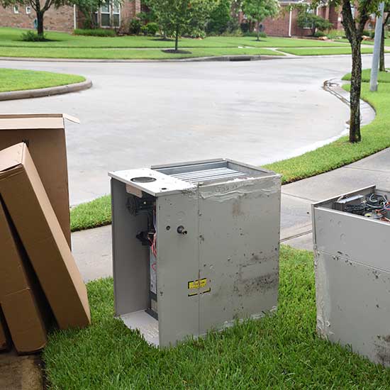 Old HVAC unit on the curb with new HVAC System replacement in boxes
